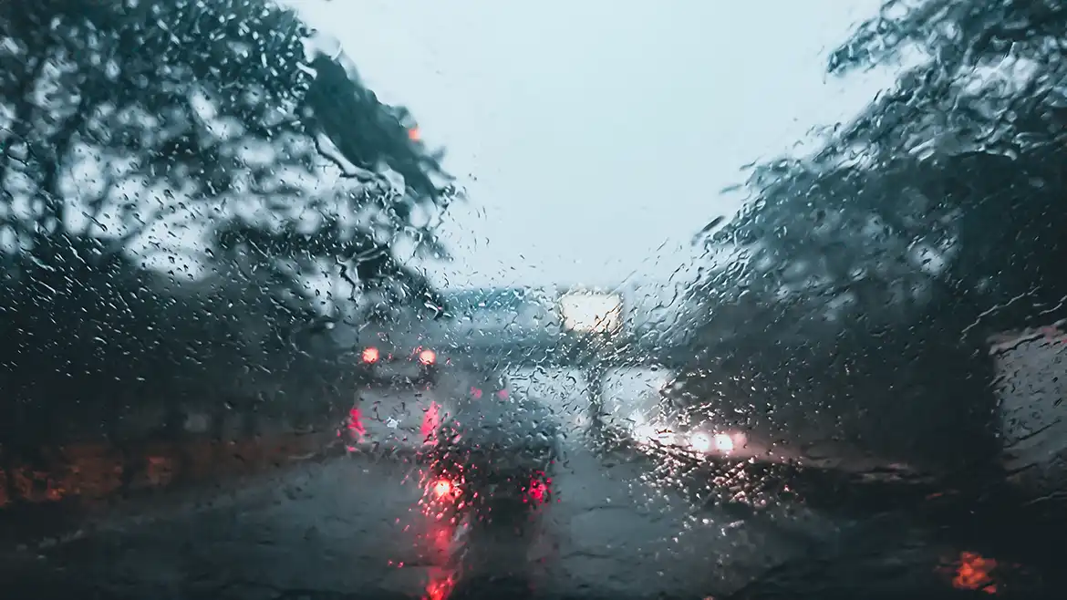 Carretera vista a través de un parabrisas mojado por la lluvia
